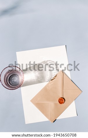Flat lay on a grey background to add your own text or logo, lifestyle digital marketing photos for instagram feed or invitation, brown enevelop and white paper