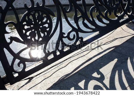 Contrasting shadows on the bridge from the beautiful cast railings and the sun's glare that shines through the bars