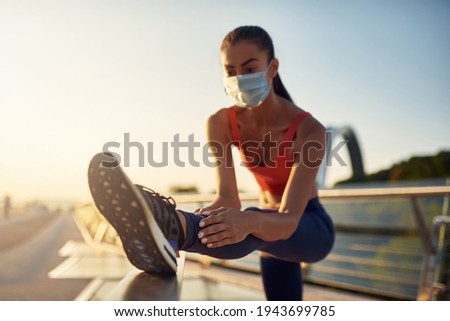 Fit girl is stretching outdoor. Slim beautiful woman workout. Jogging in the city at sunrise. Close up photo of stretching