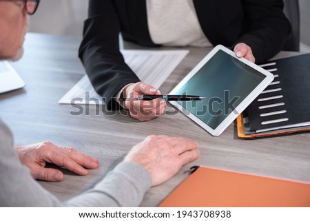 Female financial adviser giving information on digital tablet to her client Royalty-Free Stock Photo #1943708938