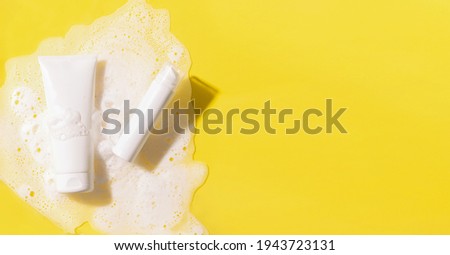 Cosmetics foam gel shampoo bright yellow background water with foam bubbles. Cosmetics products for body and face care.