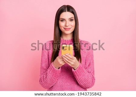 Photo of adorable pretty young lady wear knitted pullover chatting modern gadget smiling isolated pink color background