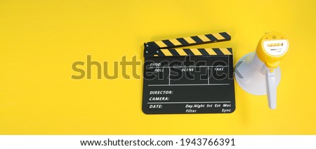 Clapperboard or movie clapper board in yellow and black color and Megaphone isolated on yellow background.it usd in cinema,movie and video production.