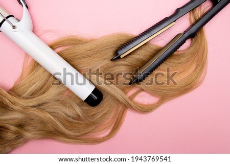Hair curling, styling and hairstyles for blond curls. Curling iron. Volumizing fine hair. Hairdresser tools. Royalty-Free Stock Photo #1943769541