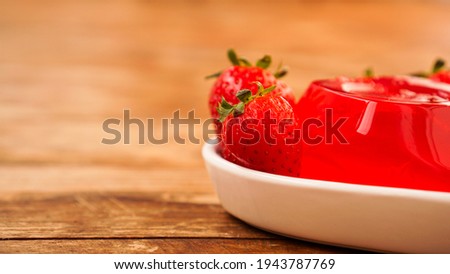 Red strawberry jelly with berries on a white plate