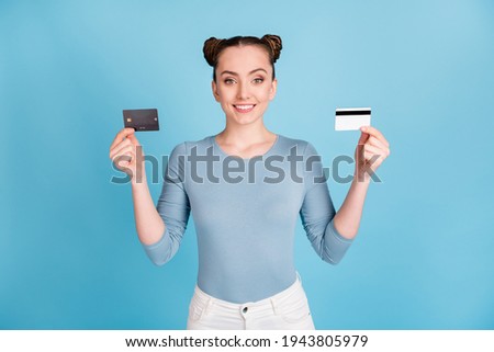 Photo of cute sweet young lady dressed casual clothes showing two credit cards isolated blue color background
