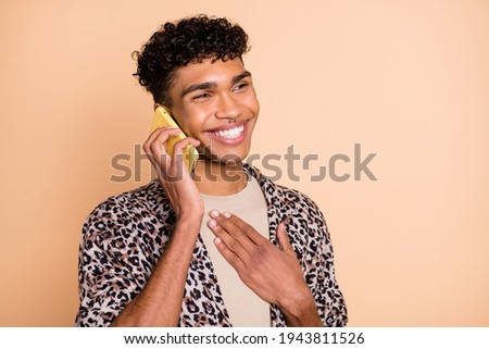 Photo of brunet optimistic guy talk telephone hand chest wear modern shirt isolated on beige background
