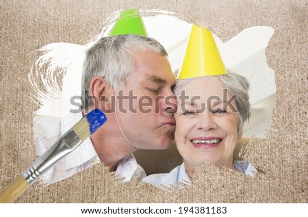 Composite image of senior couple celebrating birthday with paintbrush dipped in blue against weathered surface