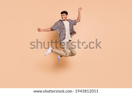 Full size profile photo of brunet optimistic guy jump wear modern shirt pants isolated on beige color background