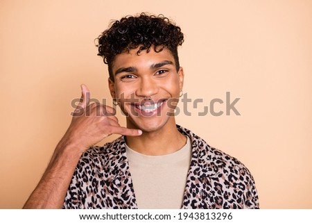 Portrait of brunet optimistic guy ask to call wear modern shirt isolated on pastel beige color background