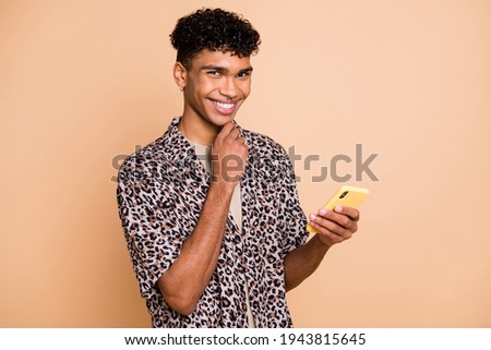 Photo of wavy hairdo cheerful dark skin person hand on chin look camera have good mood isolated on beige color background
