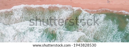 Green waves on the clear sandy beach