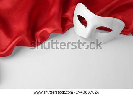 Theatre mask and red fabric on white background, above view. Space for text