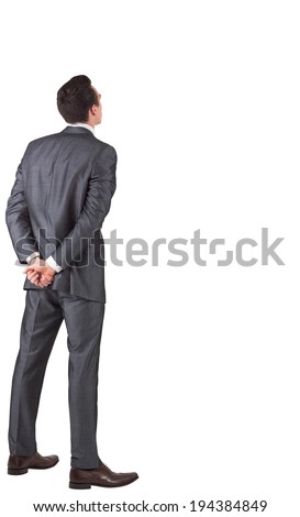 Businessman standing with hands behind back on white background Royalty-Free Stock Photo #194384849