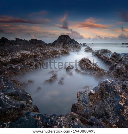 rocky beach with wonderful sunrise . long exposure photography. located at Terengganu, Malaysia.
soft and grain image.
