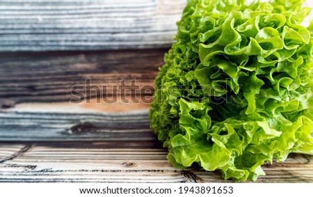 Green lettuce leaf texture , close up photo on the wooden background