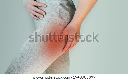 A woman suffers from piriformis syndrome, pain in buttocks muscle caused by sciatic nerve irritation Royalty-Free Stock Photo #1943903899