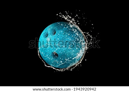 Bowling ball in water drops and splashes isolated on black background