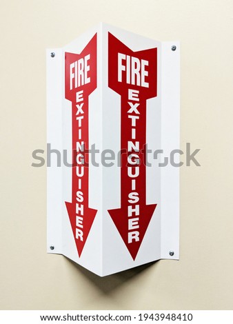Angled two sided fire extinguisher arrow sign on wall