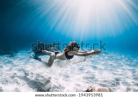 Free diver and white sand in hands over sandy sea. Freediving in tropical blue ocean
