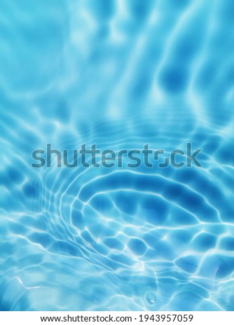 Closeup​ blur​ abstract​ of​ surface​ blue​ water. Abstract​ of​ surface​ blue​ water​ reflected​ with​ sunlight​ for​ background. Blue​ water​ splashed​ use​ for​ graphic​ design.
