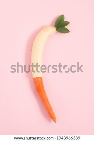2021. Easter bunny food from carrots and bananas. Pink background flat lay.