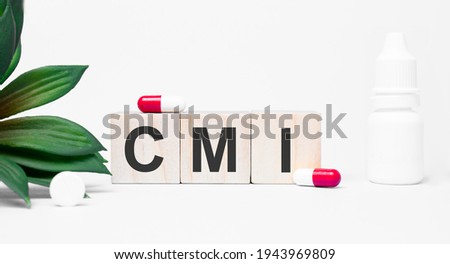 CMI the word is written on wooden cubes,plant and red pills,on white background
