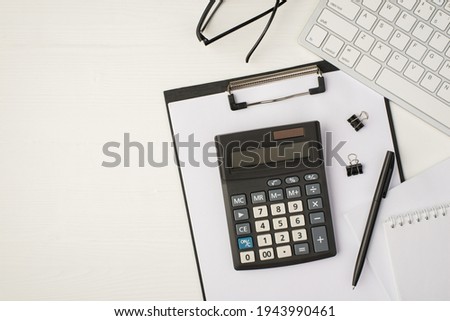 Top view photo of business workplace with keyboard glasses pen binders notebook papers and calculator on folder on isolated white background