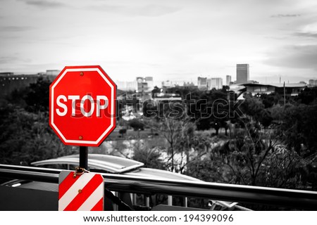 Stop sign in a black and white image with City Landscape.