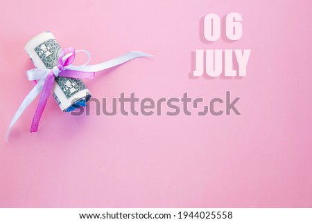 calendar date on pink background with rolled up dollar bills pinned by pink and blue ribbon with copy space.  July 6 is the sixth day of the month.