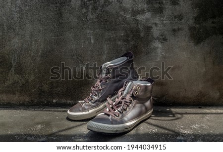 Brown Retro High Top Canvas Sneakers was placed on old cement floor. Vintage age-worn sneakers canvas shoes brown, Concept : Sometimes the long journey of life should rest. Copy space.