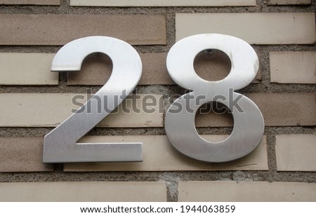 A sign on a wall with the number twenty-eight-28