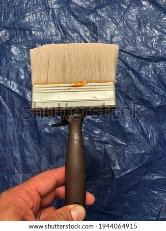 London, England, UK 19 March 2021: Holding a painting brown brush while the house renovations goes on in Kingston
