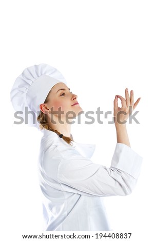 Chef woman giving a Perfect gesture with hand. Young beautiful female chef with a beaming smile standing in a toque chefs hat and whites and apron giving a Perfect gesture with her fingers