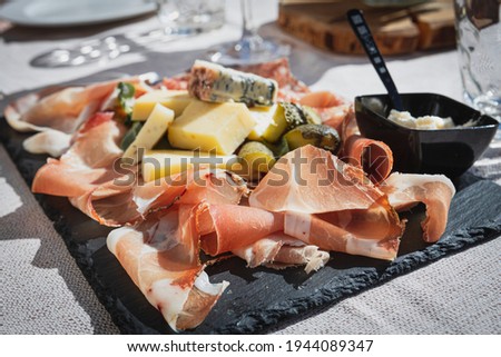 A picture of a plate of speck and typical italian salami with cheese and pickles, Cortina D'Ampezzo, Italy