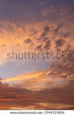Sunset in orange colors. Clouds with relaxing shapes and textures. With a city skyline and the presence of an elevated water tank