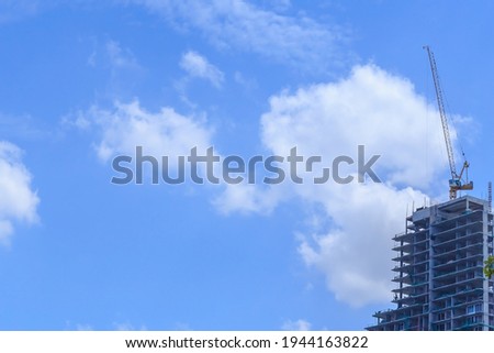 Building site under construction with blue sky and white clouds.