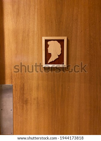 Woman's bathroom or restroom sign with a silhouette of a woman at the door. 