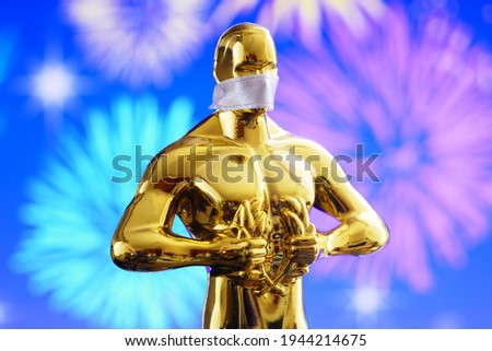 Hollywood Golden Oscar Academy award statue in medical mask on fireworks background with copy space. Success and victory concept. Oscar ceremony in coronavirus time
