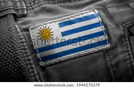 Tag on dark clothing in the form of the flag of the Uruguay.