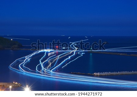 Light trails produced by fishing boats traveling at night