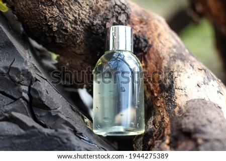 Clear cosmetic bottle for gel, shampoo, lotion for your brand logo standing on the wood in the natural environment. High quality photo