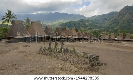 Panoramic view of Gurusina traditional Ngada village with megaliths in foreground, near Bajawa on Flores island, East Nusa Tenggara, Indonesia