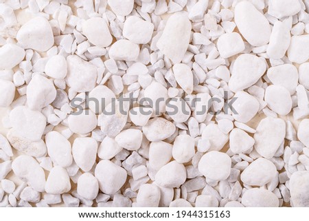 White decorative rocks and pebbles over white texture background. Nature creative layout