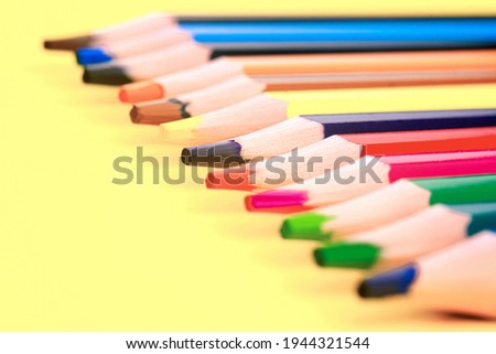 Colored pencils isolated on a yellow background. The concept of creativity development