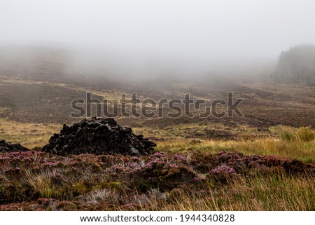 A pile of peat in the North Uist countryside, on a misty autumn morning Royalty-Free Stock Photo #1944340828