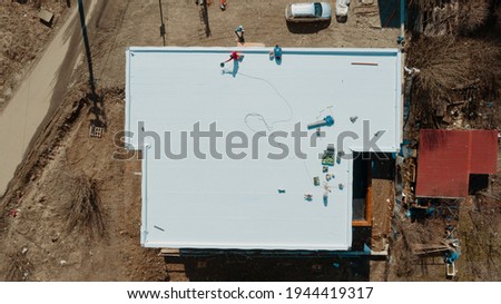 Aerial view of an apartment building with flat roof in construction, ballasted system with geotextile, PVC or EPDM membrane Royalty-Free Stock Photo #1944419317