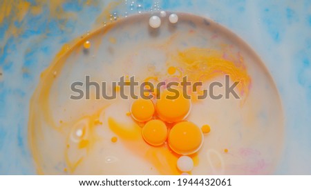 Colorful yellow, gorgeous, vibrant theme or background, cosmetic effect. Bubbles float in liquid paint. Mixing ink, oil and milk. Abstract multicolor hypnotic painting. Macro. Pattern, design