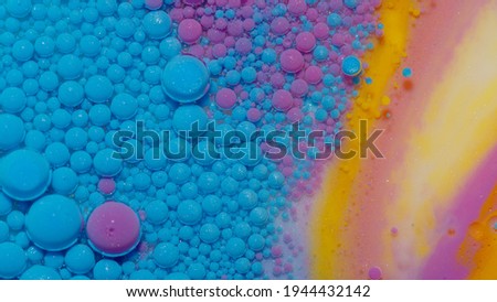 Bright neon blue bubbles oil and ink, beautiful fluorescent paint. Sparkling colorful multicolor moving close-up. Acrylic painting. Themes or wallpaper background. Abstract transformation gravitation