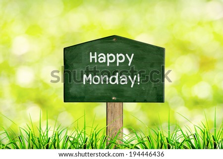 Green sign board with natural background and message Happy Monday.